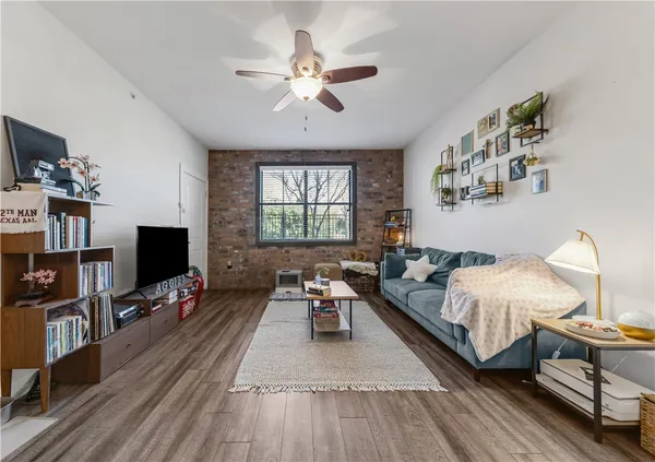 a living room with furniture a flat screen tv and a window