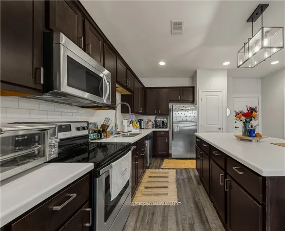 a kitchen with stainless steel appliances granite countertop a sink and stove top oven
