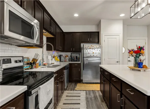 a kitchen with stainless steel appliances a sink stove and refrigerator