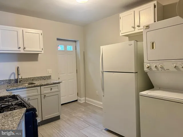 a kitchen with a refrigerator sink stove and cabinets