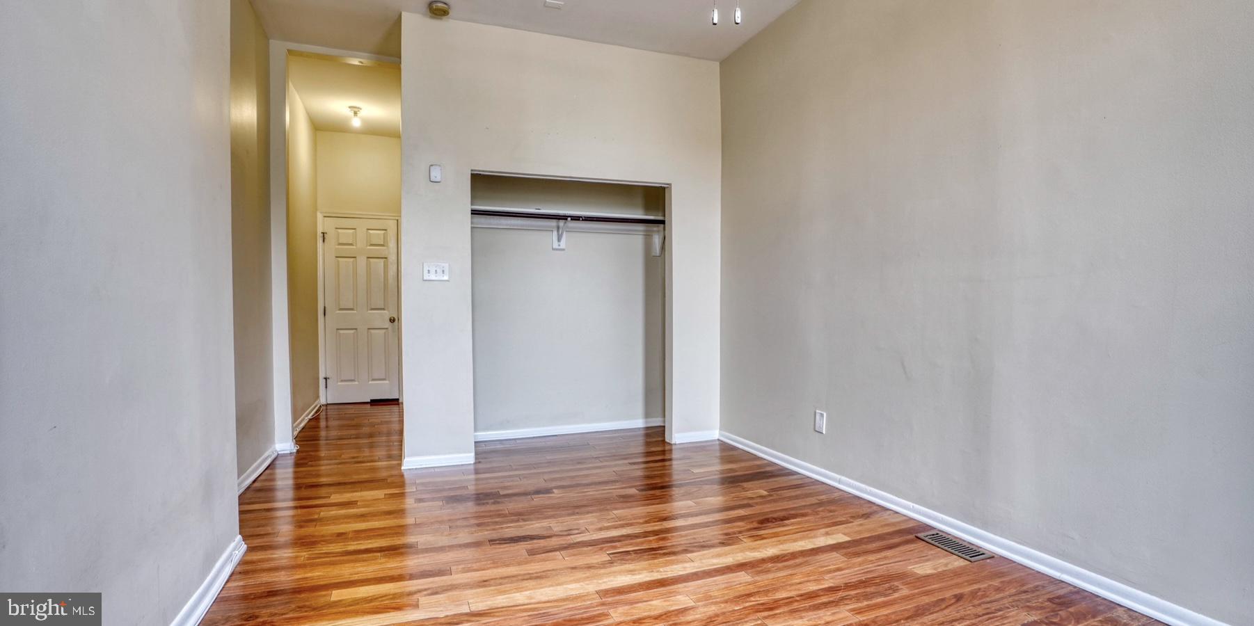 424 East North Avenue Baltimore, MD 21202 - Photo 6 of 10 a view of an empty room with wooden floor and a bathroom