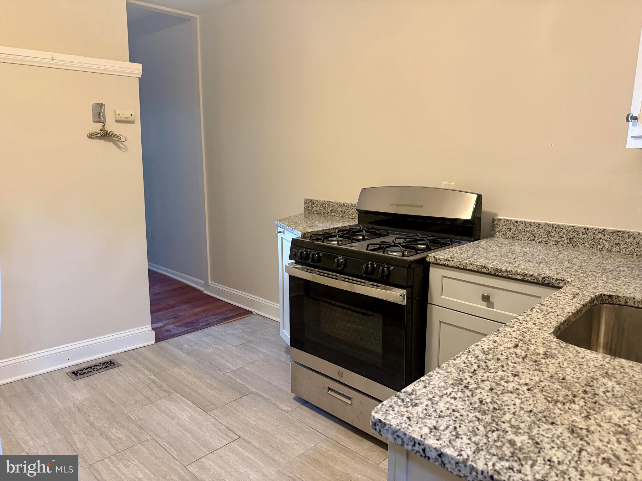 424 East North Avenue Baltimore, MD 21202 - Photo 7 of 10 a kitchen with a stove and a white cabinet