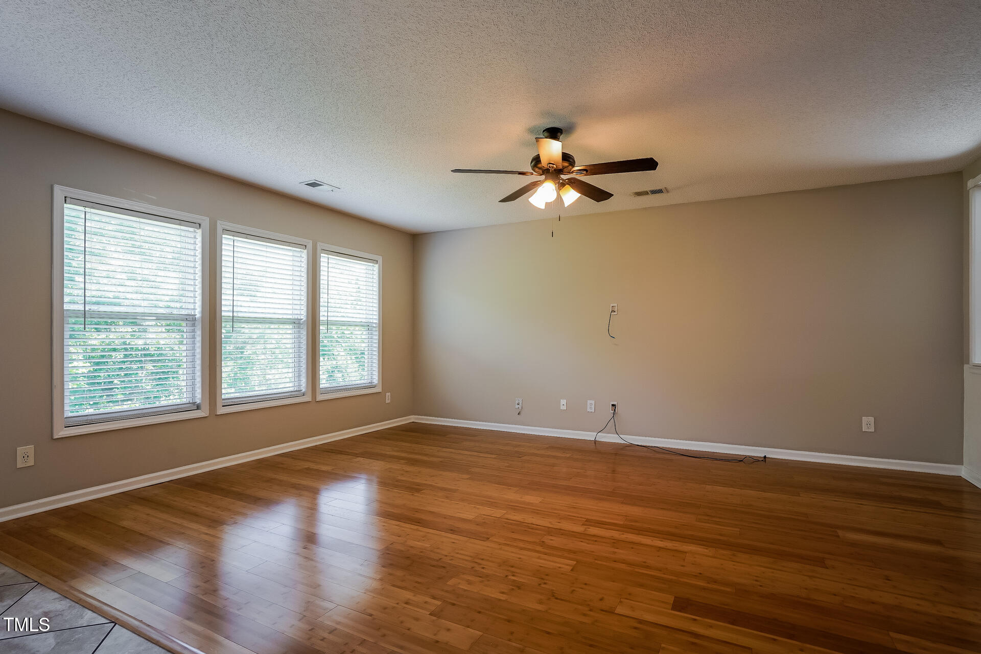 6101 Ricker Road Raleigh, NC 27610 - Photo 4 of 24 a view of an empty room with a window and wooden floor