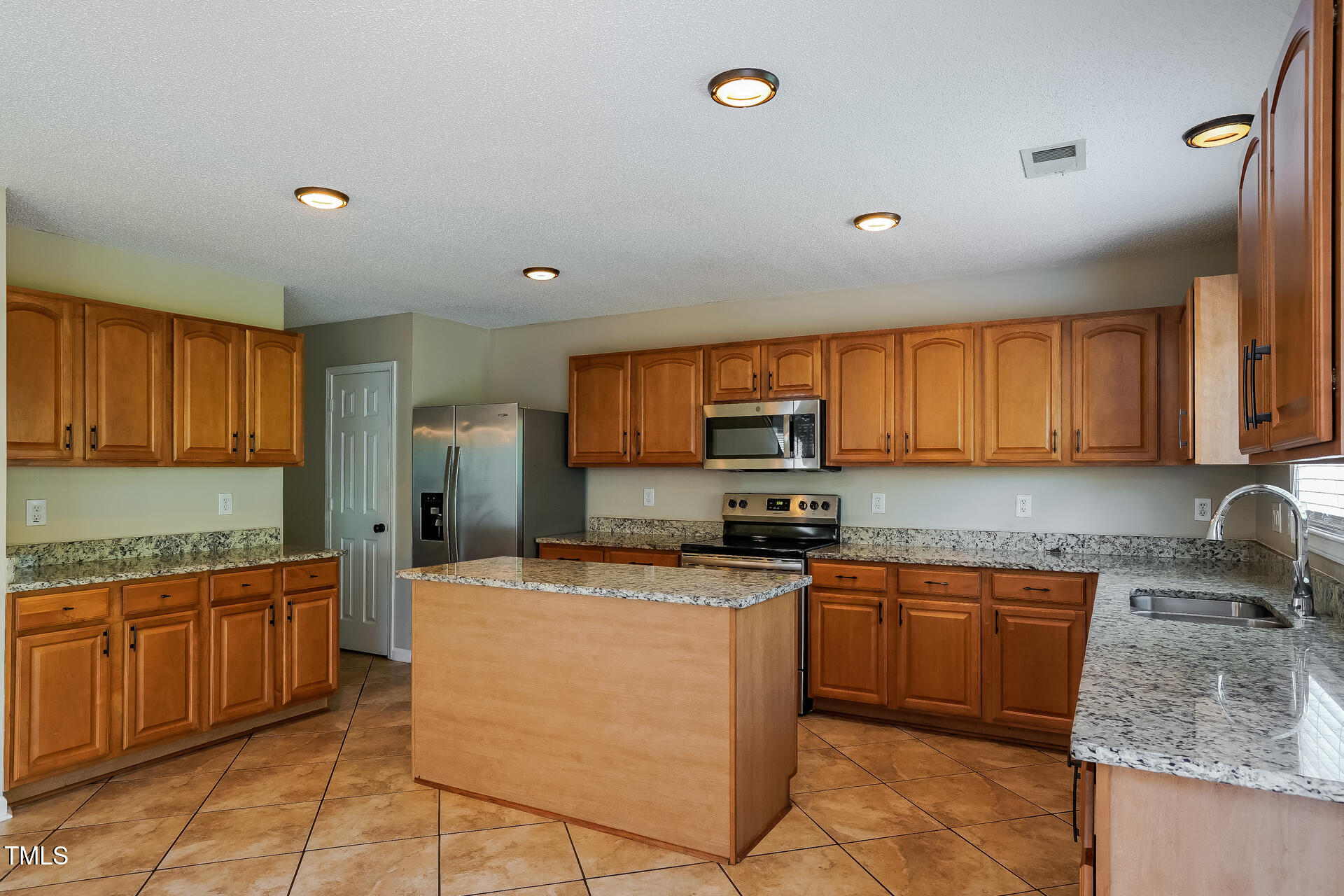 6101 Ricker Road Raleigh, NC 27610 - Photo 6 of 24 a kitchen with a sink a counter top space cabinets and stainless steel appliances