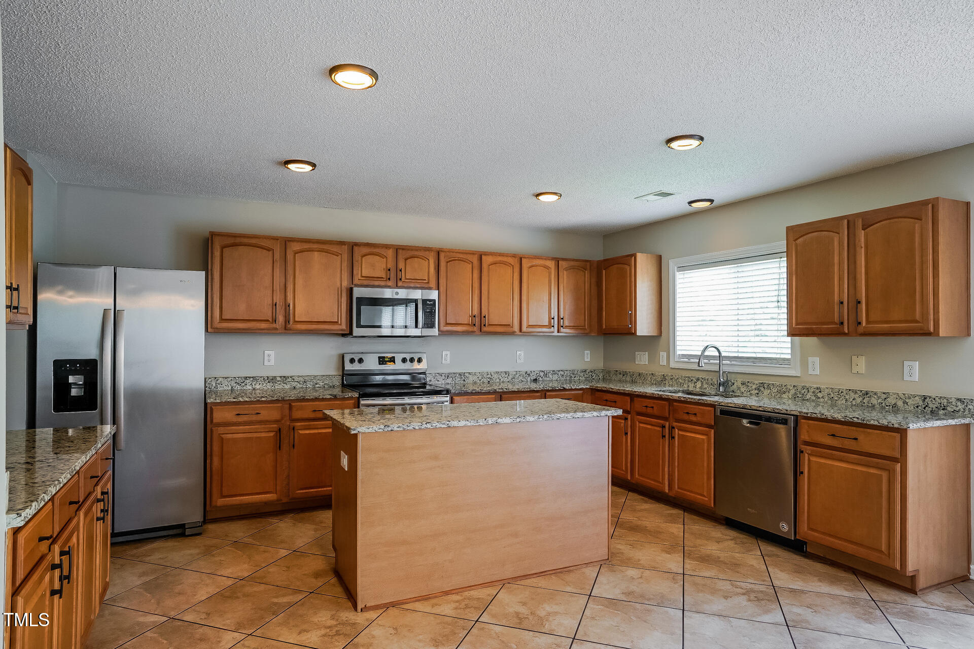 6101 Ricker Road Raleigh, NC 27610 - Photo 7 of 24 a kitchen with stainless steel appliances granite countertop a stove sink and cabinets