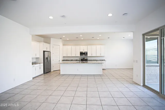 a kitchen with stainless steel appliances granite countertop a stove a sink and a refrigerator
