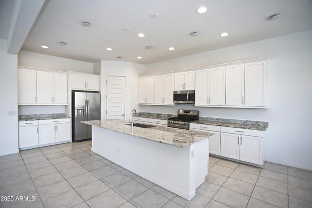 a kitchen with stainless steel appliances granite countertop a sink and a refrigerator