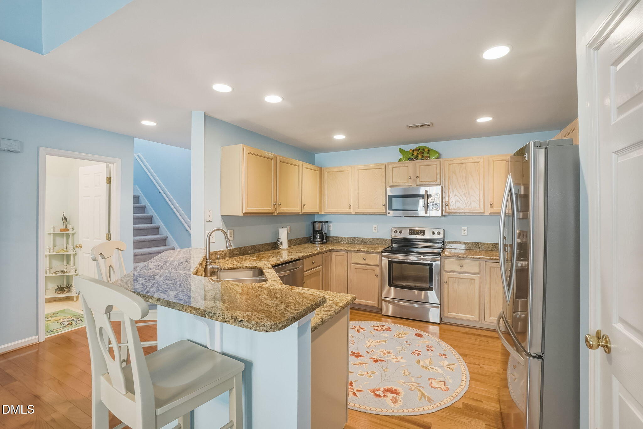 805 Sloop Pointe Lane Kure Beach, NC 28449 - Photo 6 of 20 a kitchen with kitchen island a large counter top space appliances and a center island