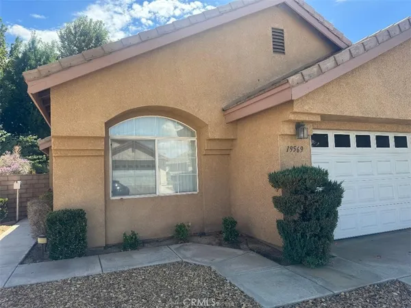 a vase with flowers sitting on a floor in front of a house