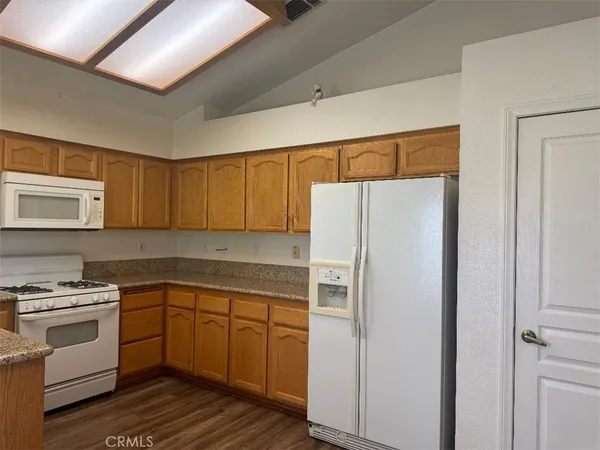 a view of a hallway with wooden floor and chandelier