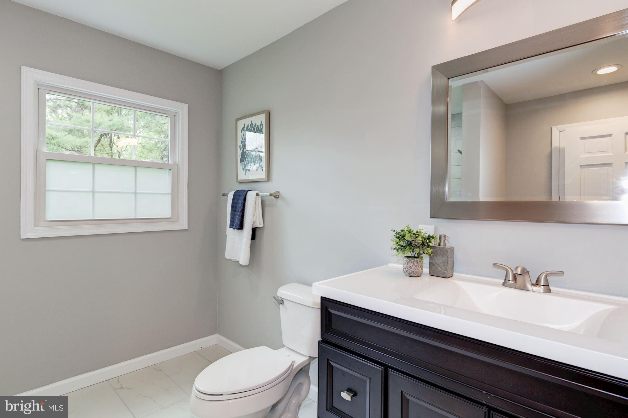 1301 Midmeadow Road Towson, MD 21286 - Photo 26 of 30 a bathroom with a granite countertop sink vanity mirror and toilet