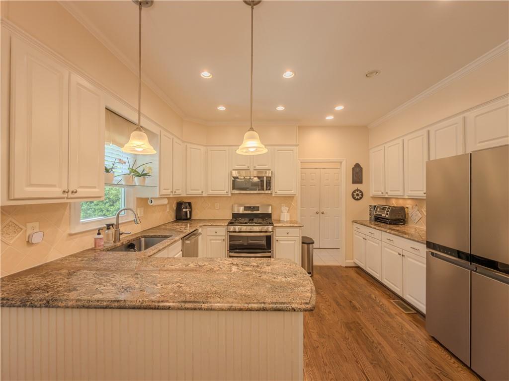 4284 Cedar Bluff Way Southwest Lilburn, GA 30047 - Photo 25 of 62 a kitchen with stainless steel appliances granite countertop a sink refrigerator and cabinets