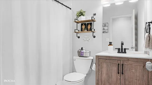 a bathroom with a sink vanity mirror and toilet