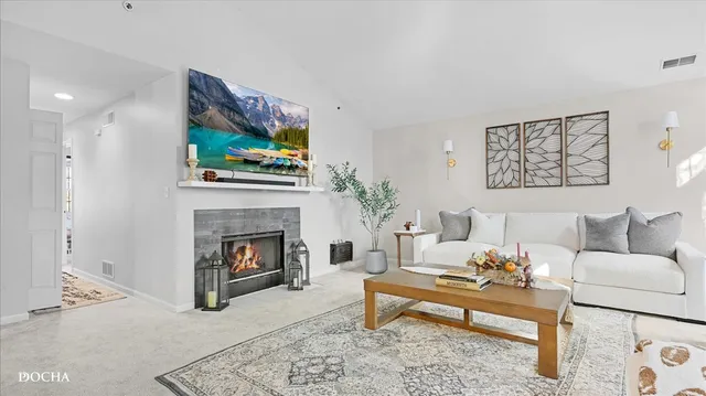a living room with furniture a fireplace and a flat screen tv