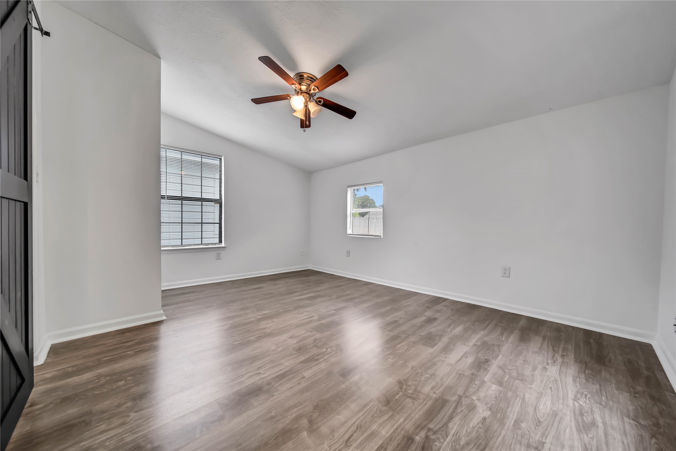 1710 Shelby Street, Unit A Houston, TX 77009 - Photo 11 of 20 an empty room with wooden floor fan and windows