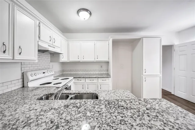 a kitchen with a refrigerator stove and white cabinets