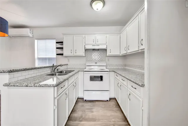 a kitchen with granite countertop a sink stove and cabinets