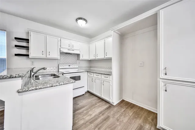 a kitchen with stainless steel appliances granite countertop a sink stove and white refrigerator with wooden floor