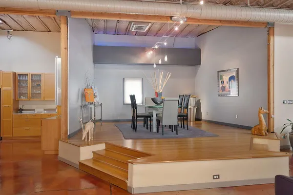 a living room with couches a flat screen tv and a dining table with the kitchen view