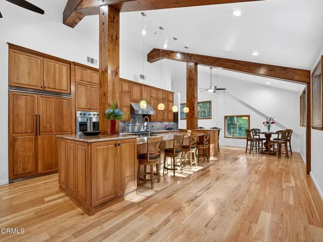 a dining hall with stainless steel appliances a dining table chairs and chandelier