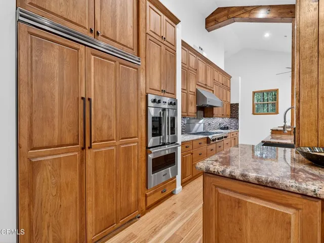 a kitchen with stainless steel appliances granite countertop a refrigerator and a sink