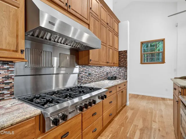 a kitchen with granite countertop stainless steel appliances and wooden cabinets