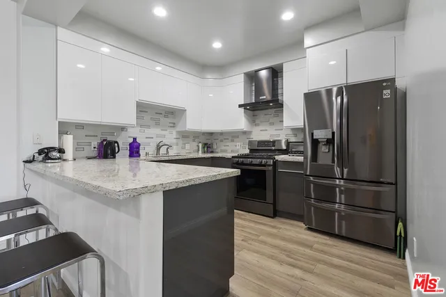 a kitchen with a sink stainless steel appliances and refrigerator