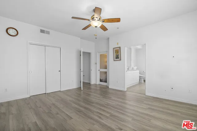 a view of a livingroom with wooden floor and a ceiling fan