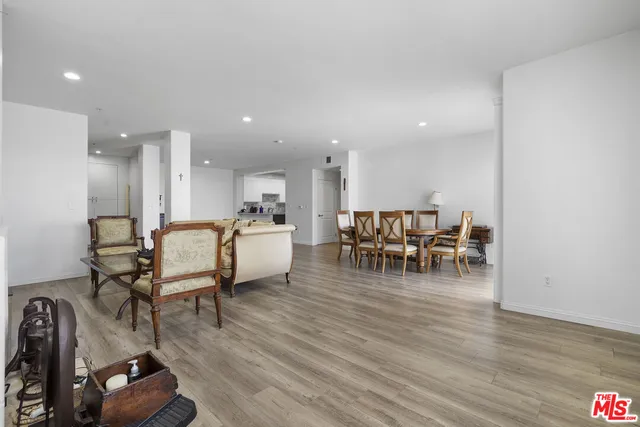 a living room with furniture and kitchen view with wooden floor