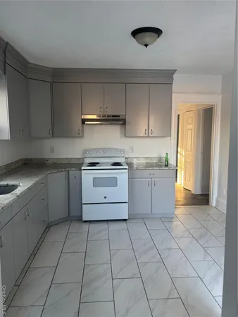 a kitchen with a stove sink and cabinets