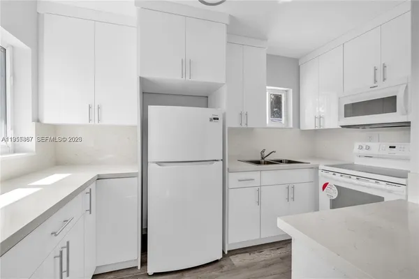 a kitchen with cabinets appliances and a sink