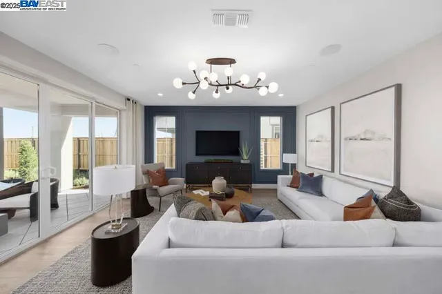 a living room with furniture a chandelier and a large window