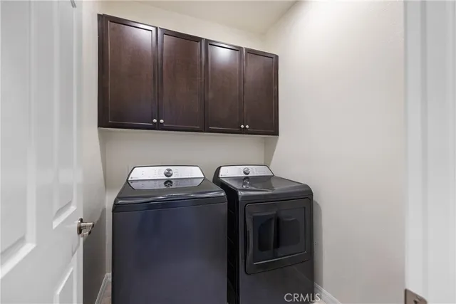 a utility room with wooden floor washer and dryer