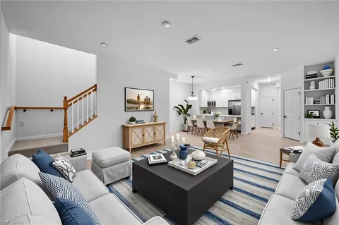 a living room with furniture kitchen view and a couch