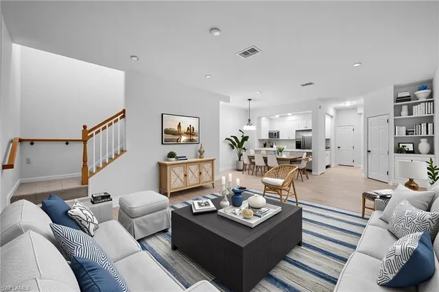 a living room with furniture kitchen view and a couch