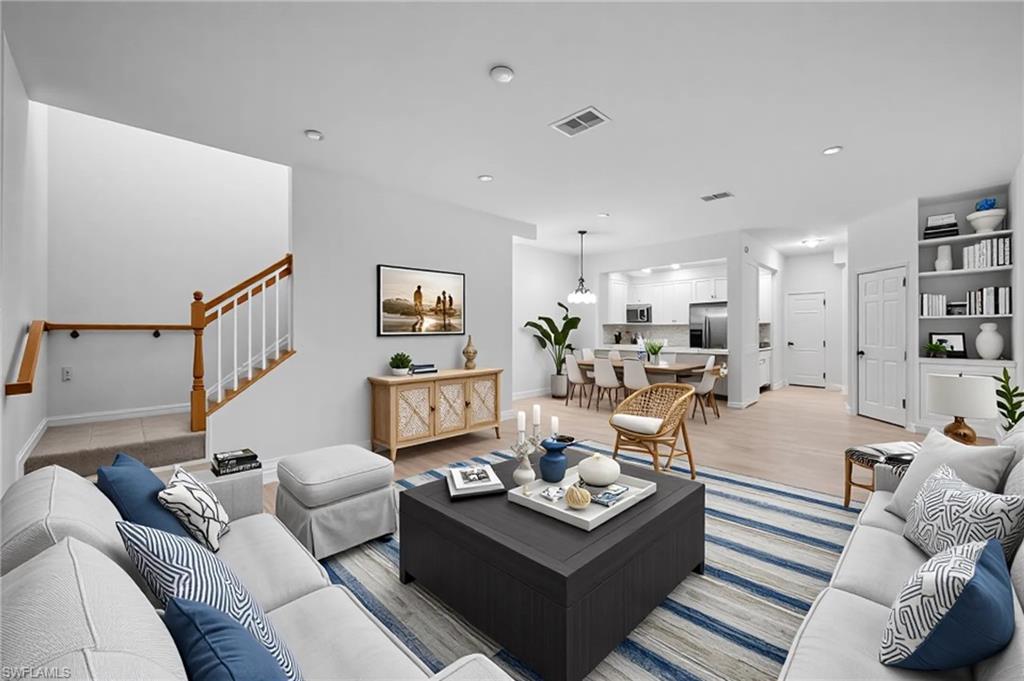 a living room with furniture kitchen view and a couch