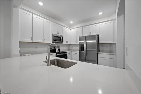 a kitchen with granite countertop a refrigerator and a sink