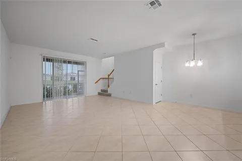 an empty room with fireplace and windows