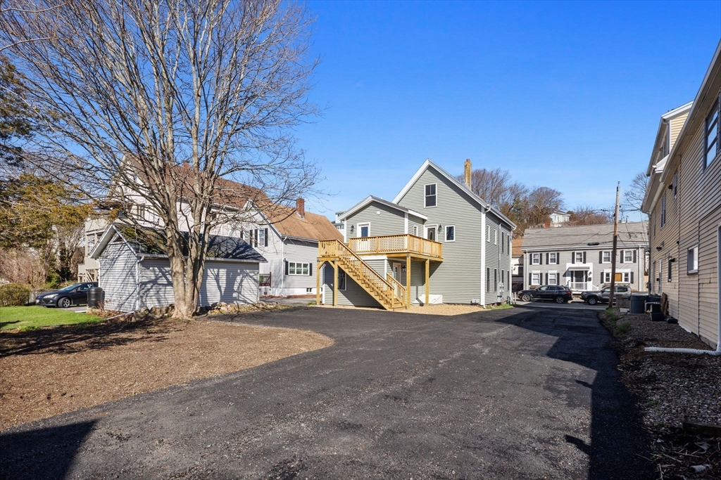 20 Beacon Street, Unit 1 Gloucester, MA 01930 - Photo 13 of 17 a view of a white house next to a road with big trees