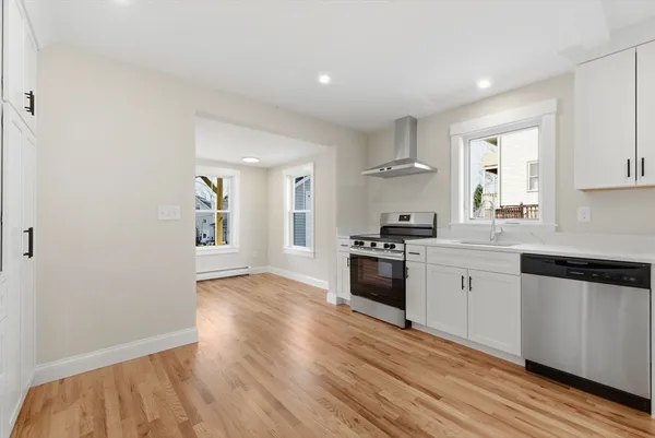 a kitchen with granite countertop a refrigerator stove top oven and sink