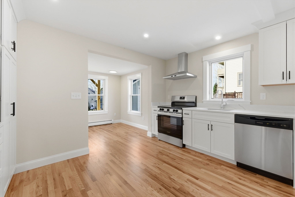 20 Beacon Street, Unit 1 Gloucester, MA 01930 - Photo 2 of 17 a kitchen with granite countertop a refrigerator stove top oven and sink