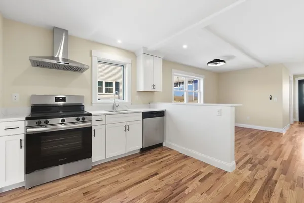 a kitchen with a stove and white cabinets