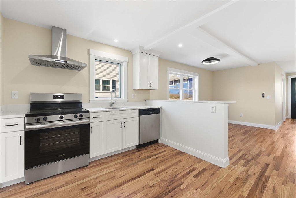 20 Beacon Street, Unit 1 Gloucester, MA 01930 - Photo 3 of 17 a kitchen with a stove and white cabinets