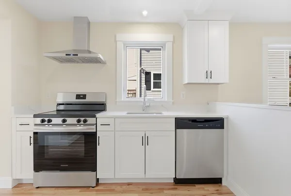 a kitchen with cabinets stainless steel appliances and wooden floor