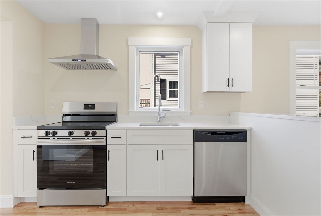 20 Beacon Street, Unit 1 Gloucester, MA 01930 - Photo 4 of 17 a kitchen with cabinets stainless steel appliances and wooden floor