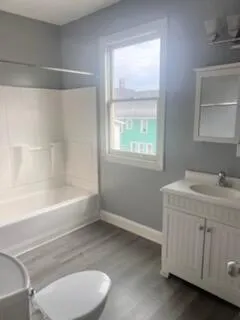 a bathroom with a granite countertop sink toilet and bathtub