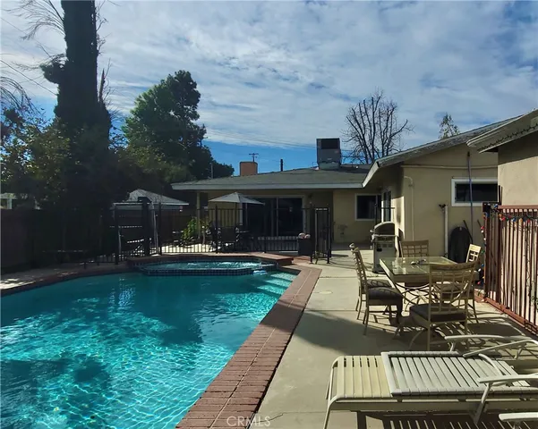 a view of a chairs and table in the back yard of the house