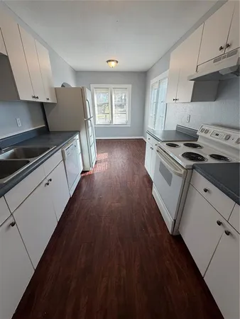 a kitchen with wooden floors and appliances