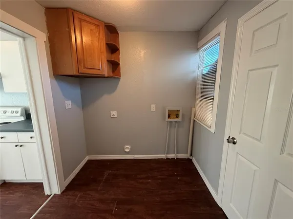 a view of hallway with walk in closet and wooden floor