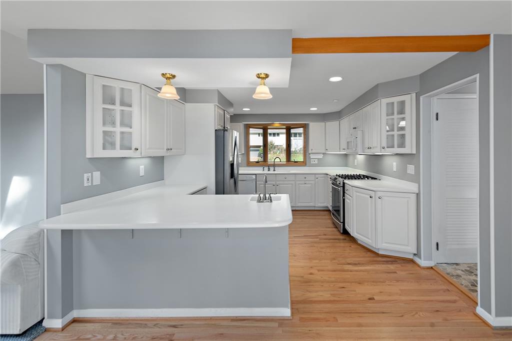 8210 Bramble Lane Pittsburgh, PA 15237 - Photo 9 of 25 a large white kitchen with wooden floors and stainless steel appliances